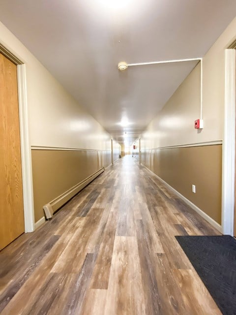 a long hallway with wood flooring in a building